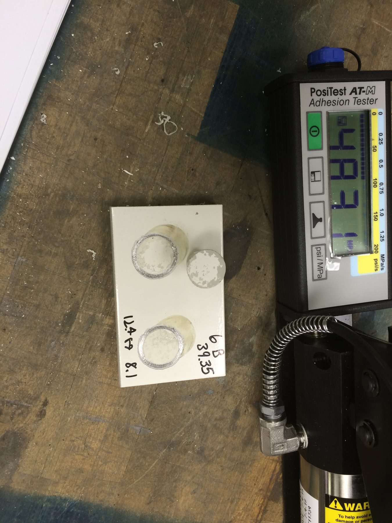 PosiTest adhesion tester reading 4.931 MPa on a sample plate.