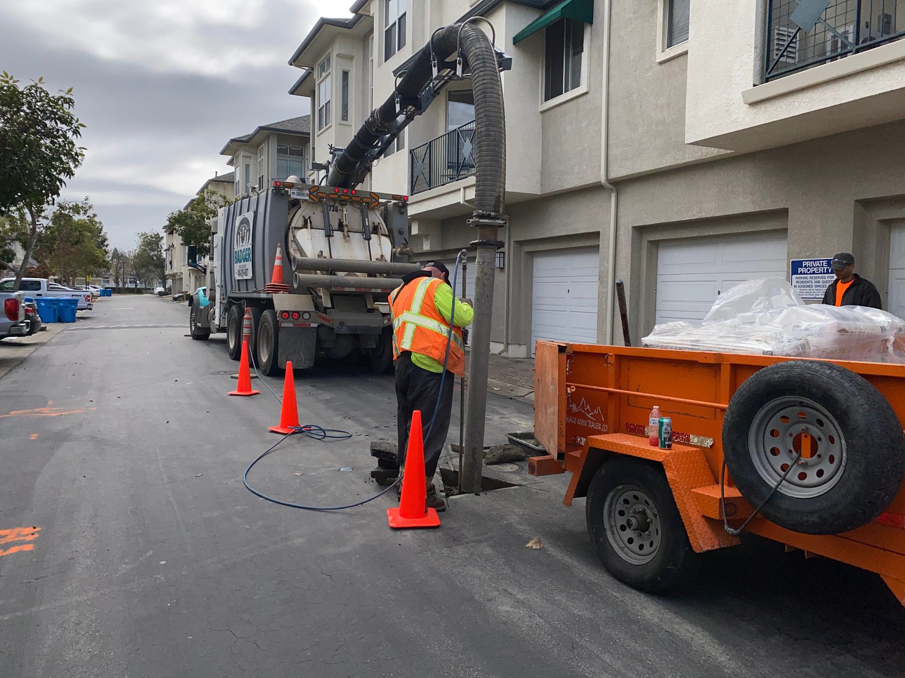 Vacuum excavation in a paved work area, with a suction hose in a cut in the asphalt